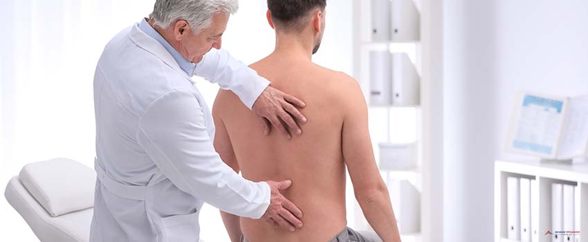 ACG-Chiropractor examining patient with back pain