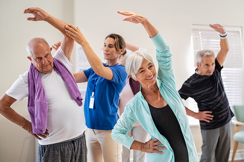 ACG Save Download Preview Active seniors doing exercise with physiotherapist at nursing home gym