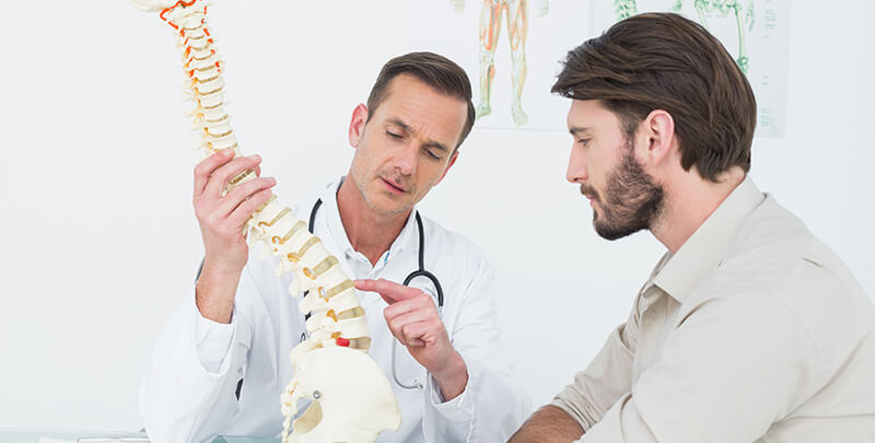 ACG doctor explaining the spine to a patient in medical office